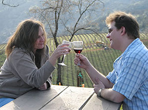 2 people share a glass of wine at a tasting event.